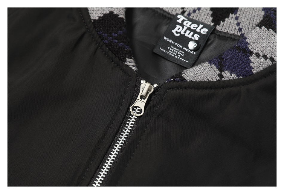 Close-up of a black jacket's silver front zipper, patterned collar, and sewn-in neck label.