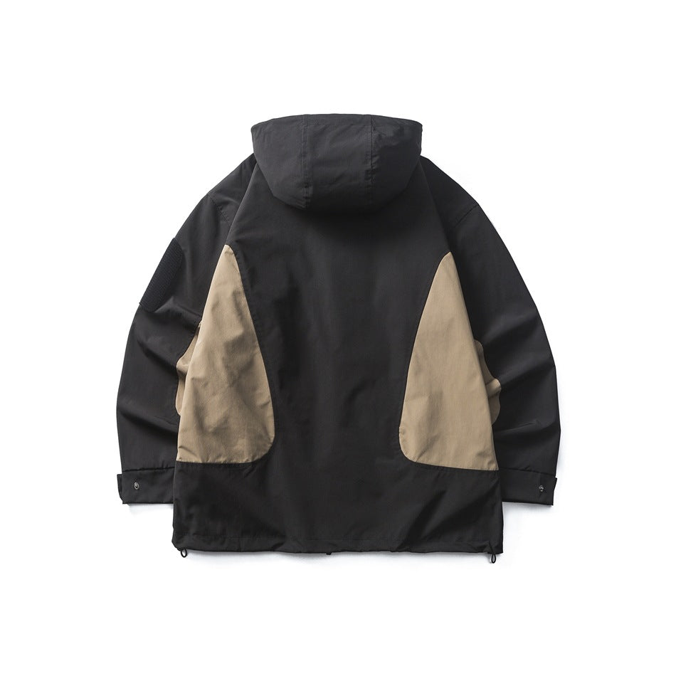 Back view of a black hooded jacket with large tan side panels and adjustable cuffs.