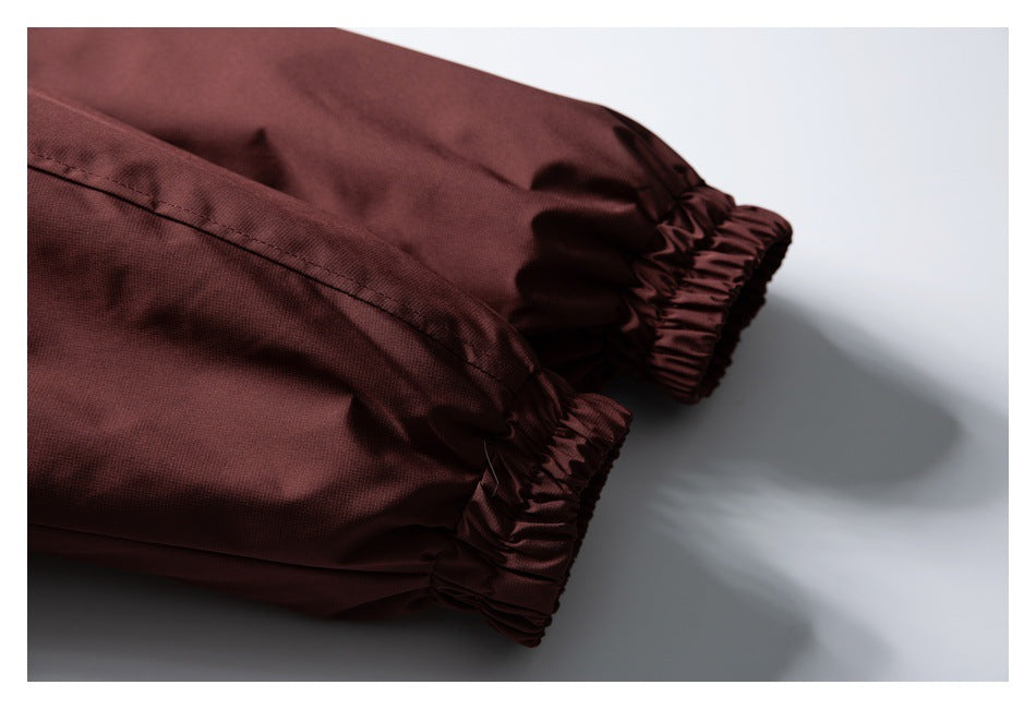 Close-up of two elastic cuffs on a burgundy garment against a pale background.