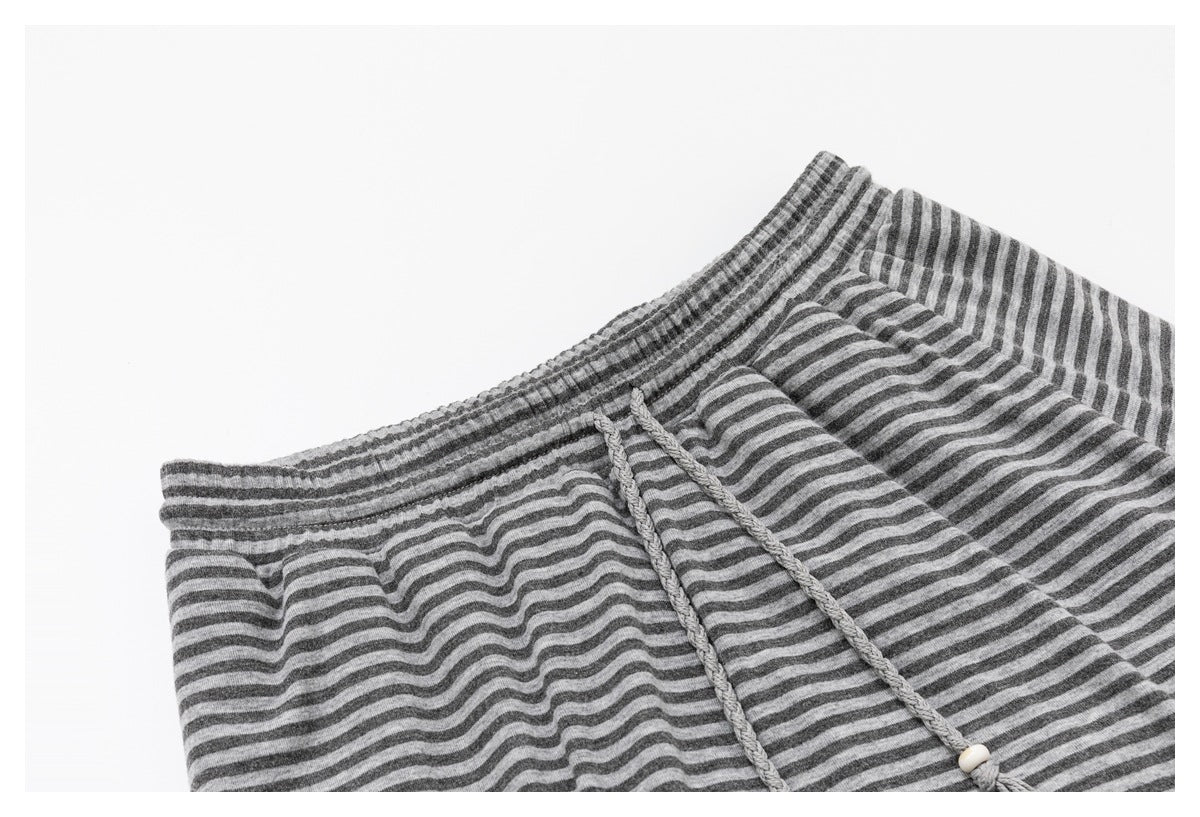 Close-up of the gray striped waistband and braided drawstrings with light-colored tips.