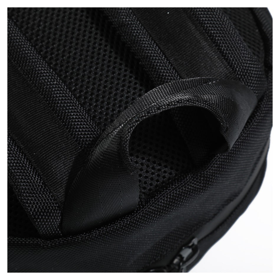 Close-up of the padded mesh back and curved shoulder strap of a black backpack.