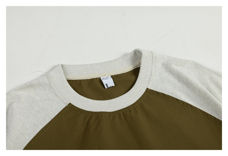 Close-up of the front crew neck and raglan seams, with an olive body and light heathered sleeves.
