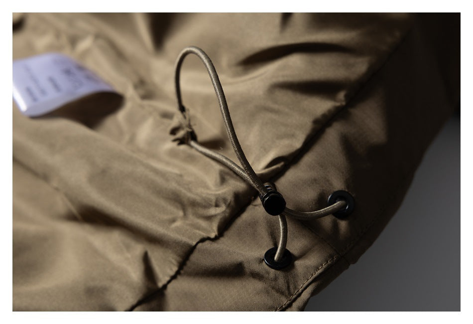 Close-up of an olive-brown garment's adjustable elastic drawcord, eyelets, and cord lock.