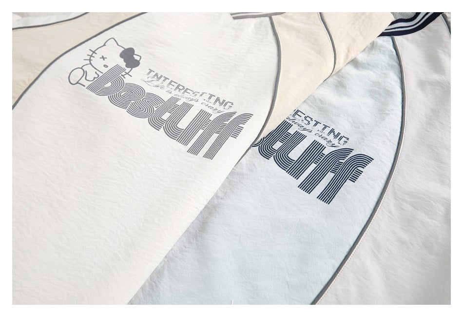 Close-up of cream and pale blue tops with gray piping and large printed graphics.