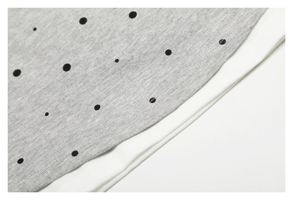 Close-up of the gray dotted T-shirt hem layered over white fabric.