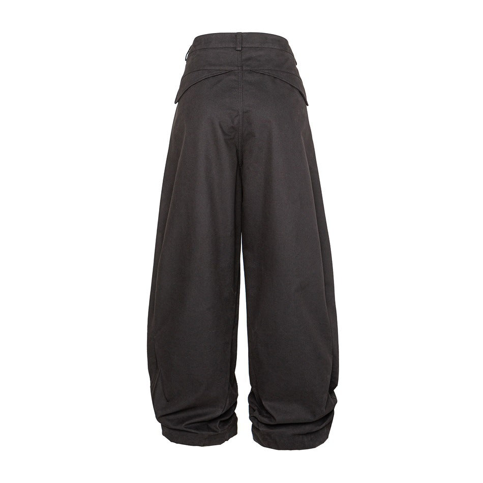 Full rear view of dark charcoal wide-leg trousers with curved back pocket flaps and gathered hems.