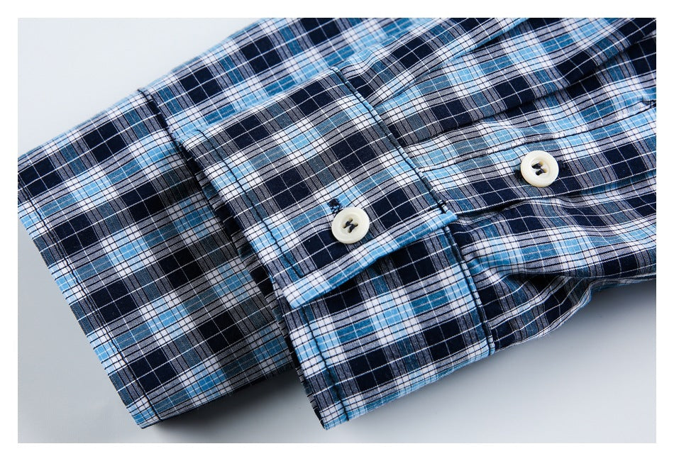 Close-up of a plaid shirt cuff with two cream buttons in navy, light blue, and white checks.
