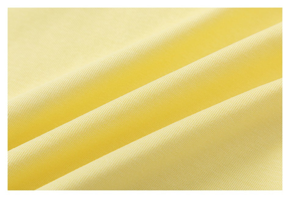 Close-up of pale yellow fabric with a fine woven texture and soft diagonal folds.
