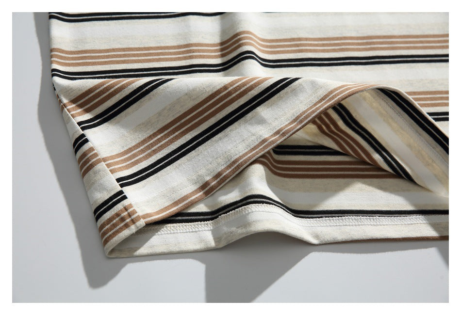 Close-up of the inside stitched hem and folded striped fabric of a cream shirt.