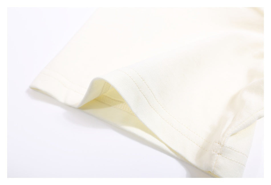 Close-up of the off-white T-shirt sleeve hem with visible double stitching.
