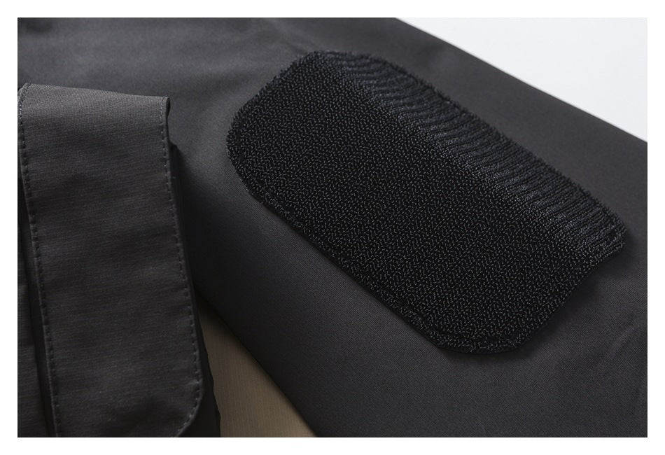 Close-up of a black jacket with a rectangular hook-and-loop patch and matching fabric tab.