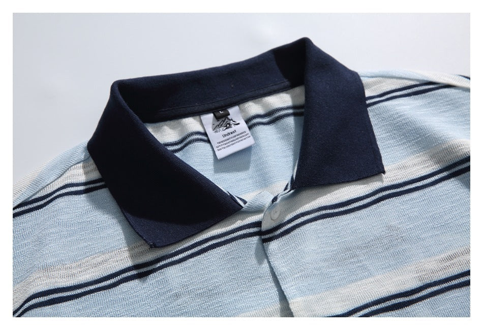 Close-up of the polo's navy collar, top button, and interior neck label.