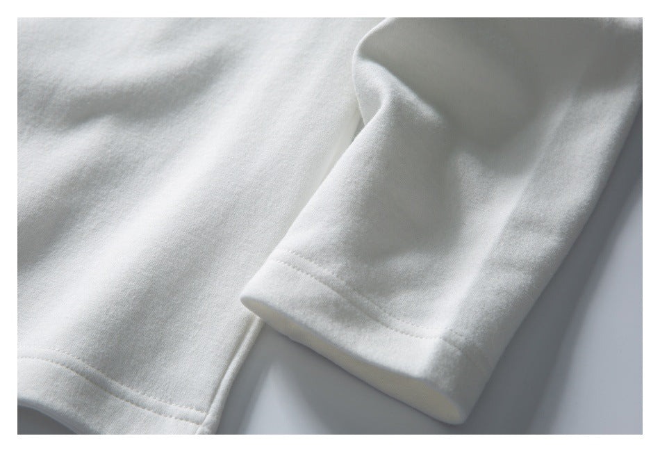 Close-up of a white garment sleeve and hem with visible stitching.