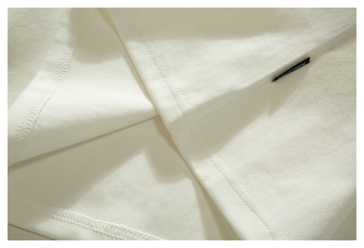 Close-up of the white T-shirt's seams and hem, with a small black fabric label.
