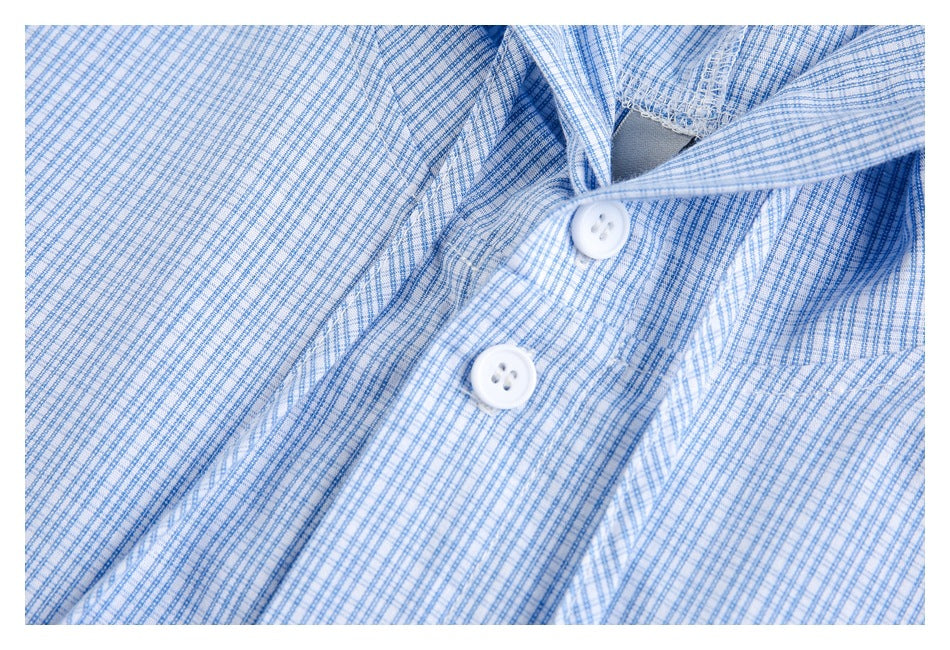 Close-up of white buttons and the fine blue check pattern on the shirt front.