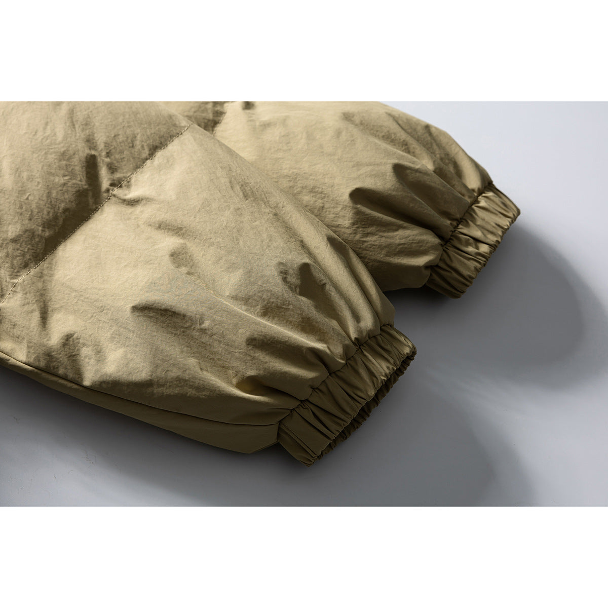 Close-up of a beige jacket's gathered elastic cuffs and sleeve construction.
