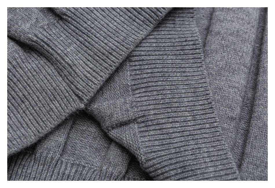 Gray knit garment close-up with overlapping wide ribbed edges and a smooth knit section.
