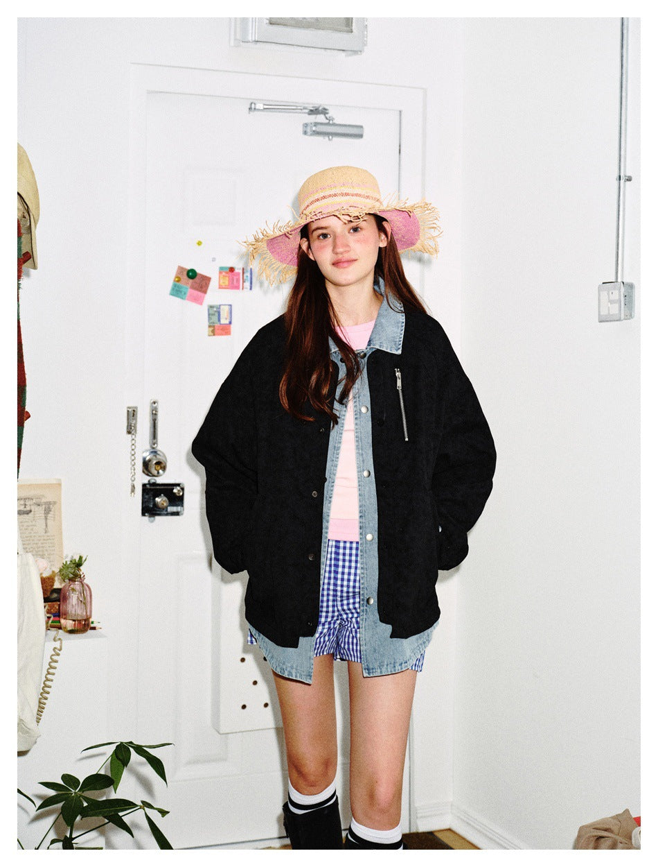 Model wearing a black jacket over a light blue denim-look layer with a pink top and checked shorts
