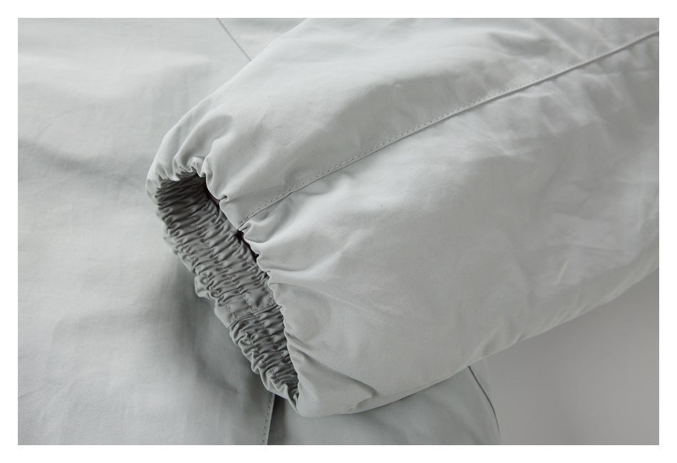 Close-up of a gathered elastic cuff on a light gray garment.
