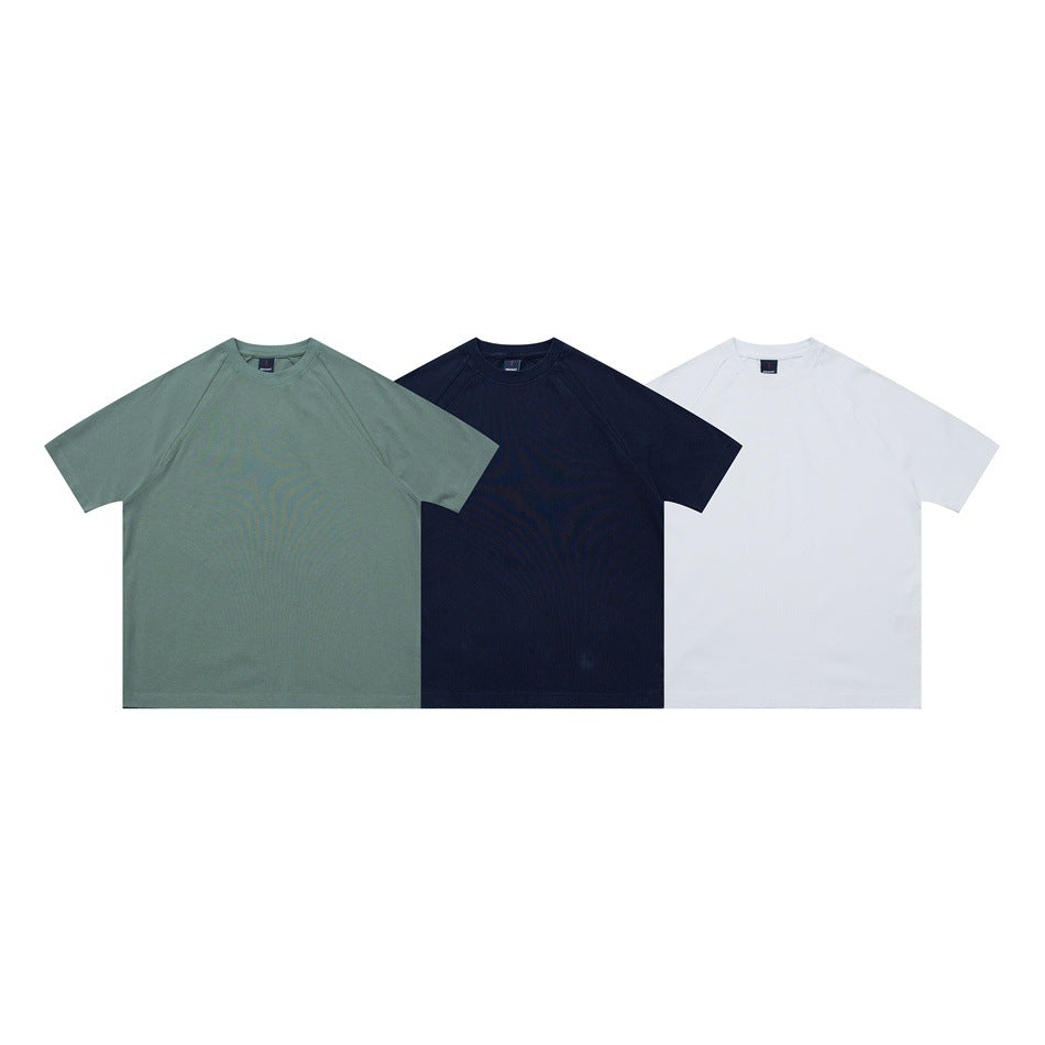 Three short-sleeve raglan crew-neck shirts shown from the front in sage green, navy, and white.