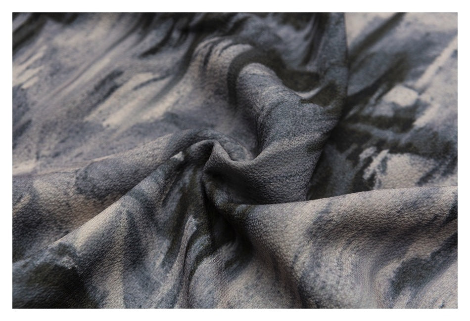Close-up of softly textured gray and black patterned fabric gathered into folds.