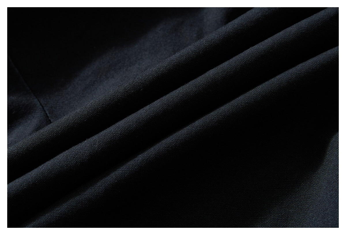 Close-up of dark fabric showing its fine surface texture and soft folds.