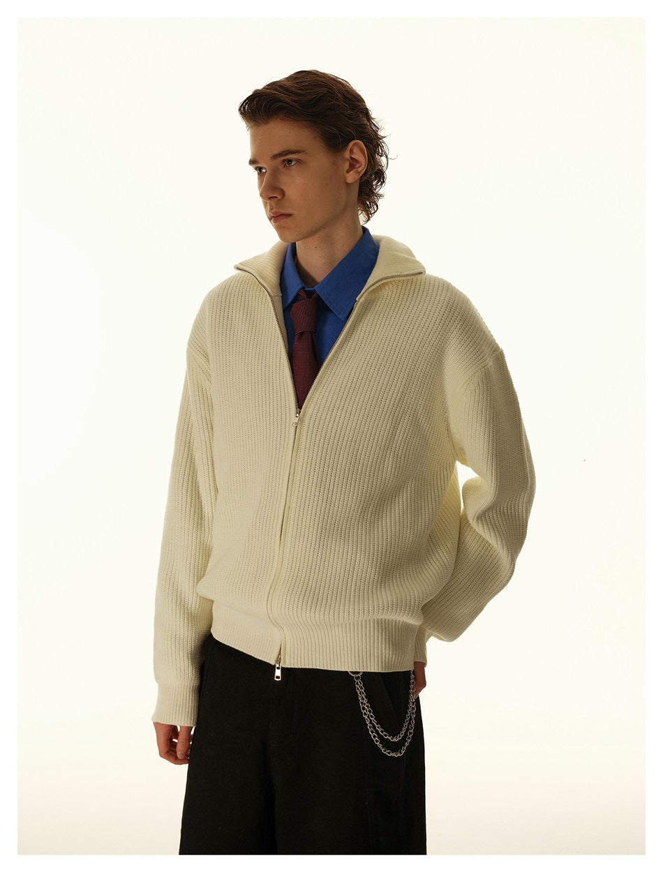 Model wearing an apricot rib-knit zip cardigan with folded-open collar over a blue shirt, red tie and black trousers