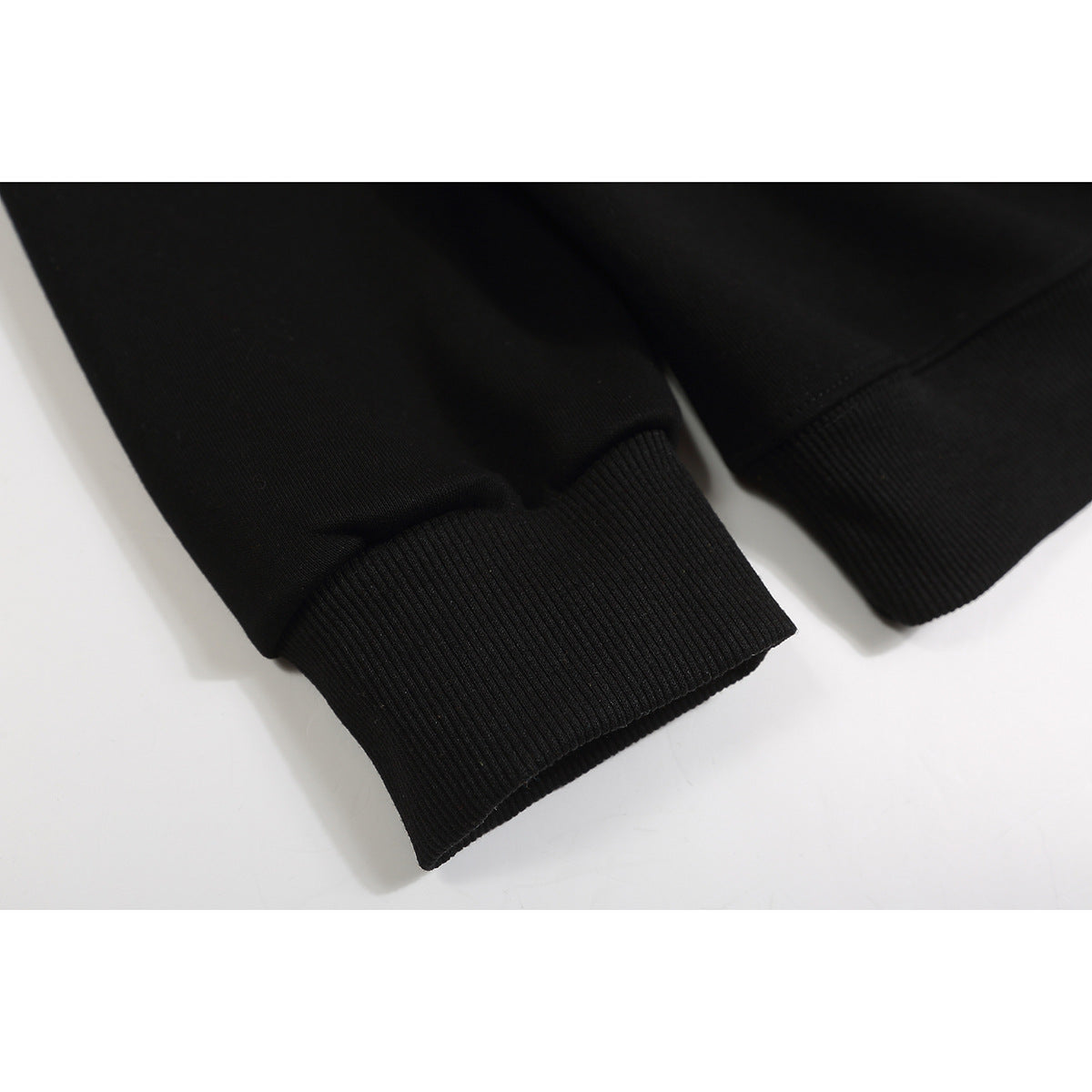 Close-up of the black sweatshirt's ribbed sleeve cuffs.