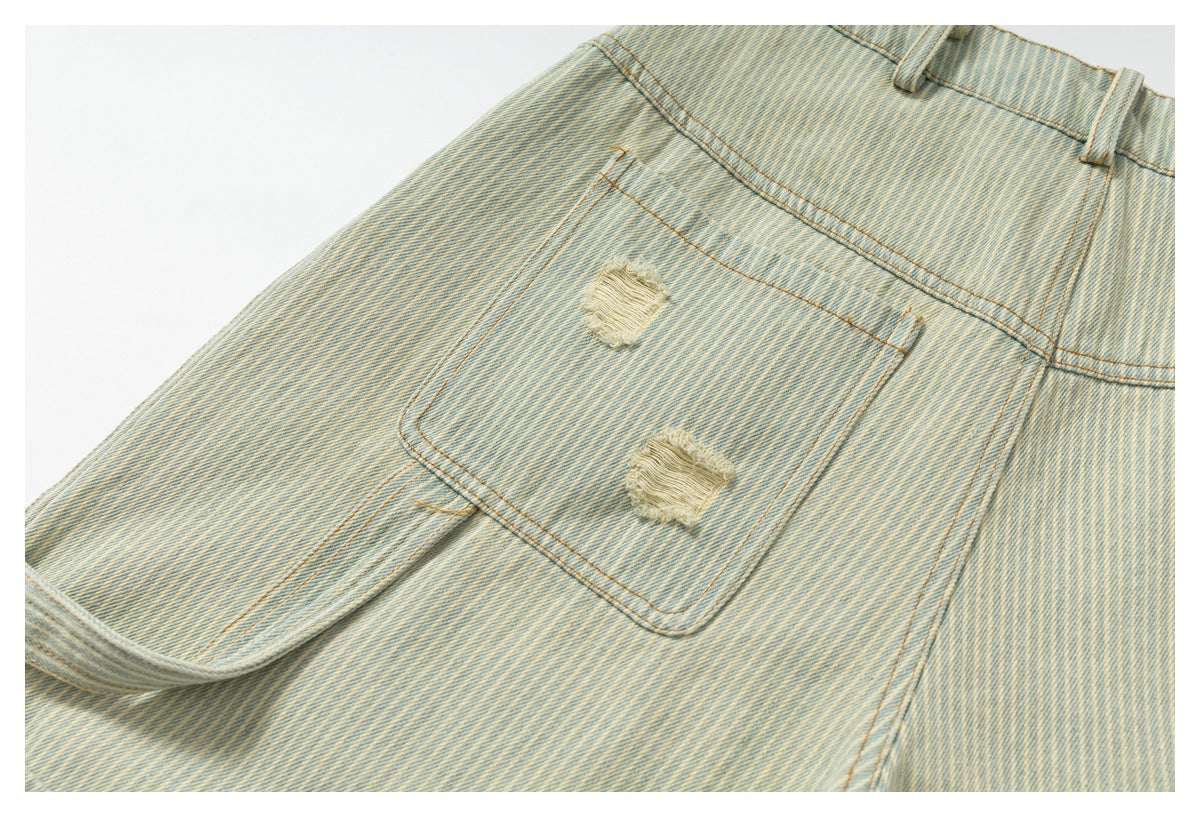 Close-up of light washed striped denim with a stitched pocket, belt loop, and two distressed patches.