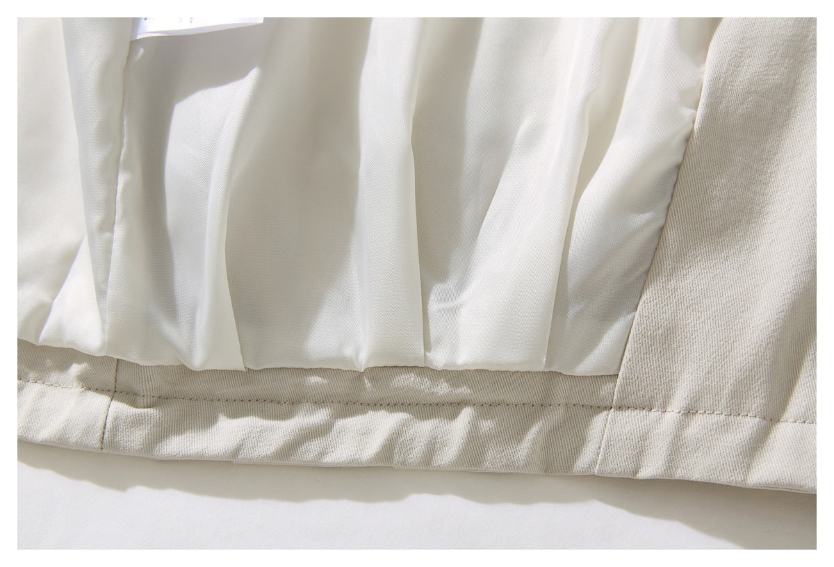 Close-up of the ivory jacket's white pleated lining and inner hem stitching.