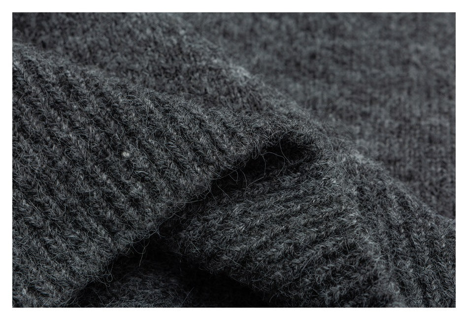 Close-up of charcoal-gray knit fabric folded to show its textured stitches and edge.