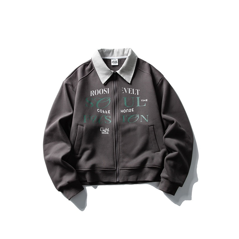 Dark gray zip-up jacket with light gray collar, green and white chest lettering print and ribbed cuffs, flat lay