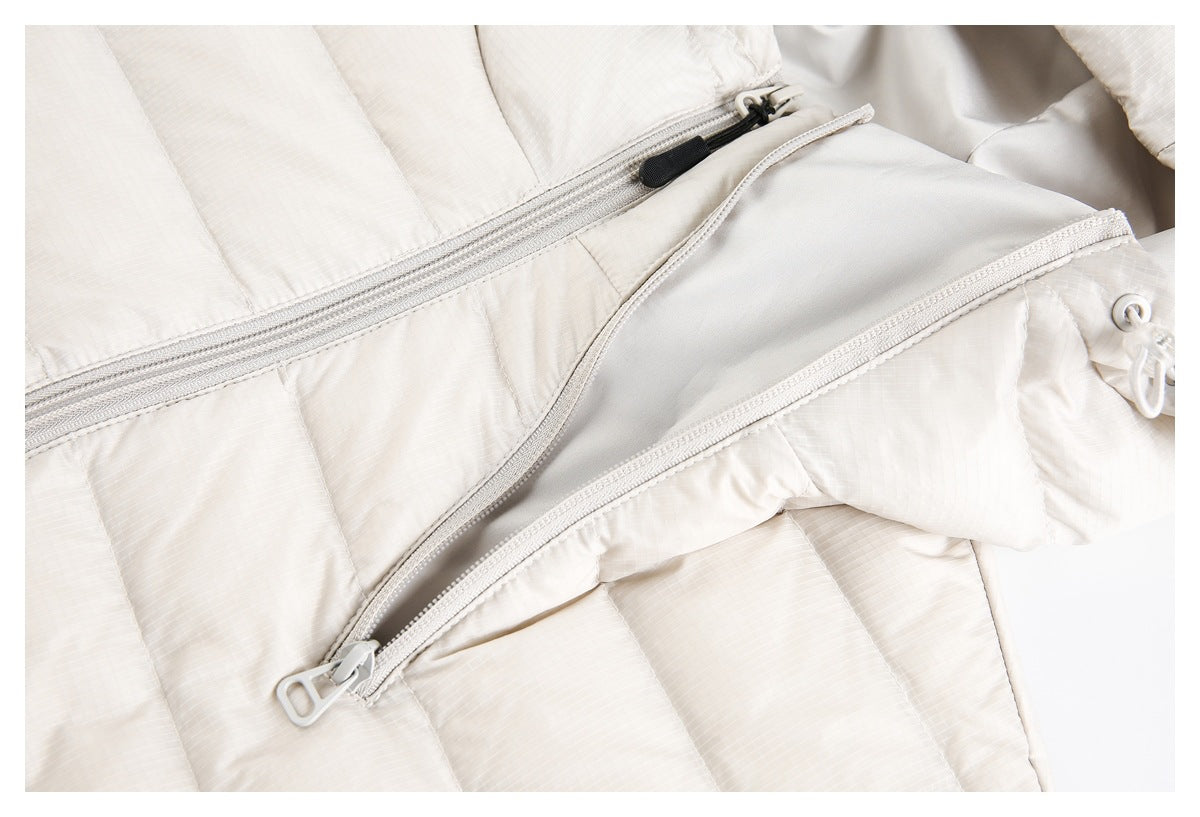 Close-up of an open zippered pocket on the off-white quilted jacket.