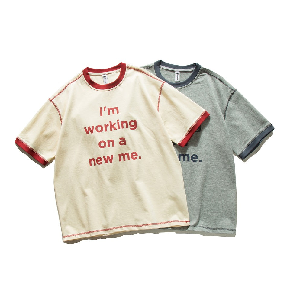 Two short-sleeve crew-neck T-shirts: ivory with red trim and lettering, and gray with dark trim and lettering.