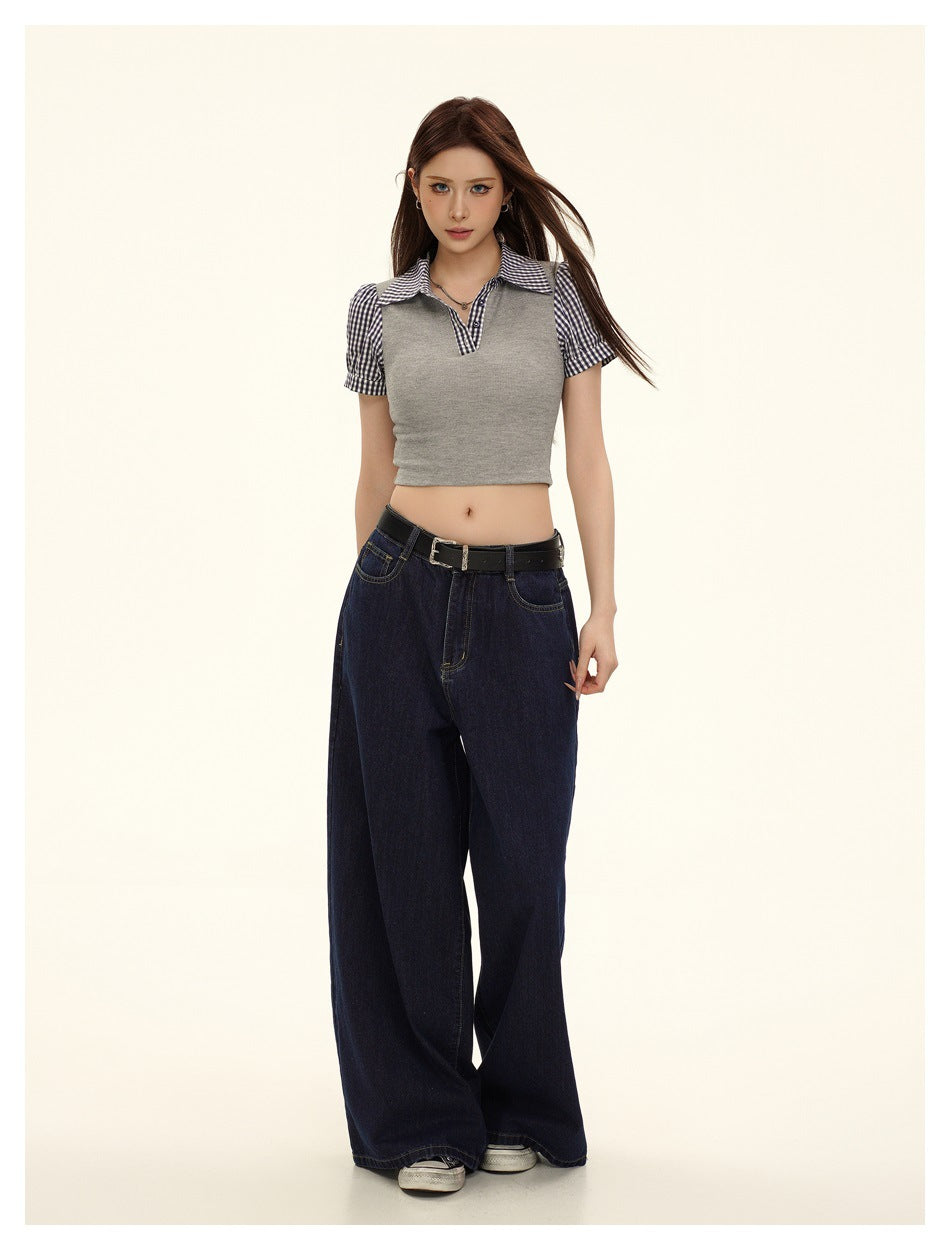 Full-length front view of a model wearing a gray cropped gingham-trim top and dark wide-leg jeans.