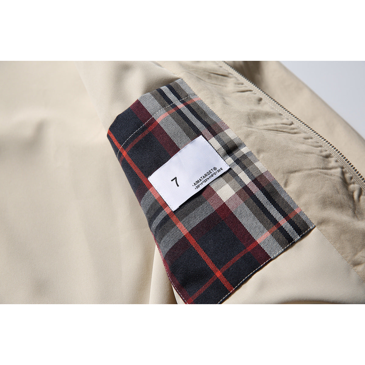 Close-up of the jacket’s red, navy, and white plaid inner lining and sewn-in label.