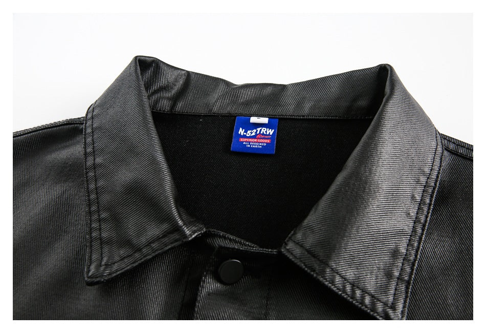 Close-up of a black jacket’s pointed collar, top snap, and blue sewn-in neck label.