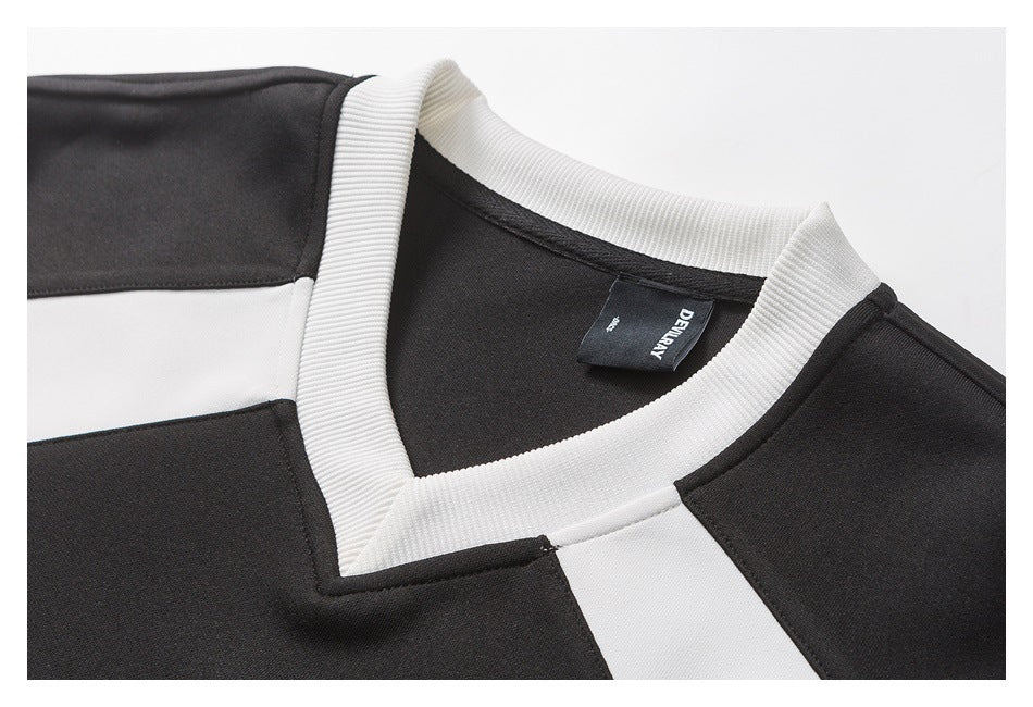Close-up of the black shirt's white ribbed V-neck collar and contrasting shoulder panels.
