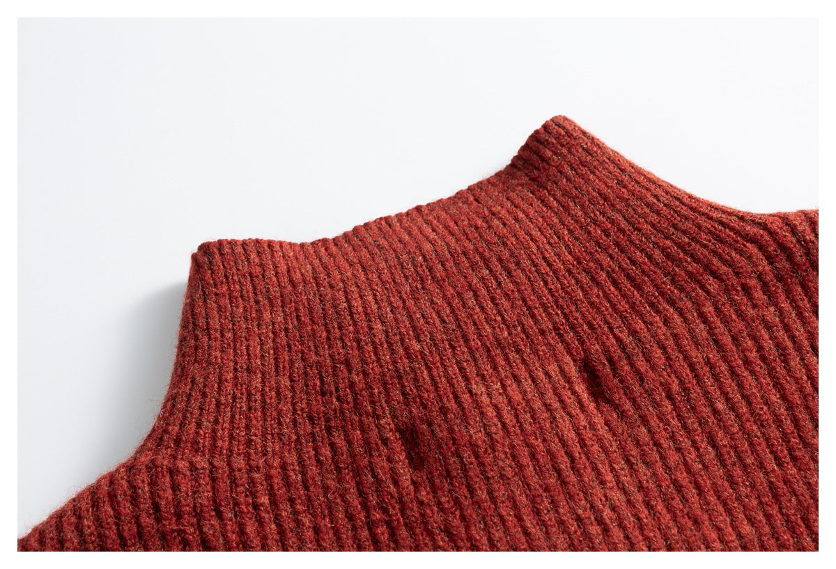 Close-up of the rust-red rib-knit garment's high collar and shoulder.