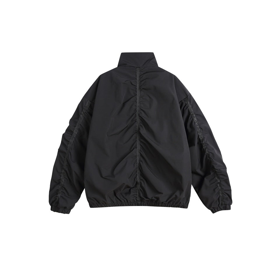 Back view of a black jacket with a high collar, gathered center seam, and elastic cuffs and hem.