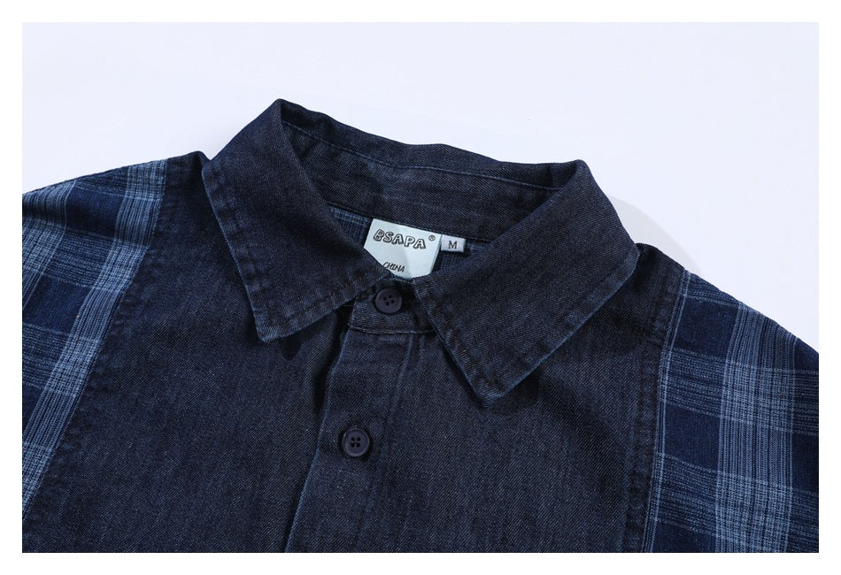 Flat lay of a dark navy button-up shirt with a pointed collar and blue plaid sleeves.