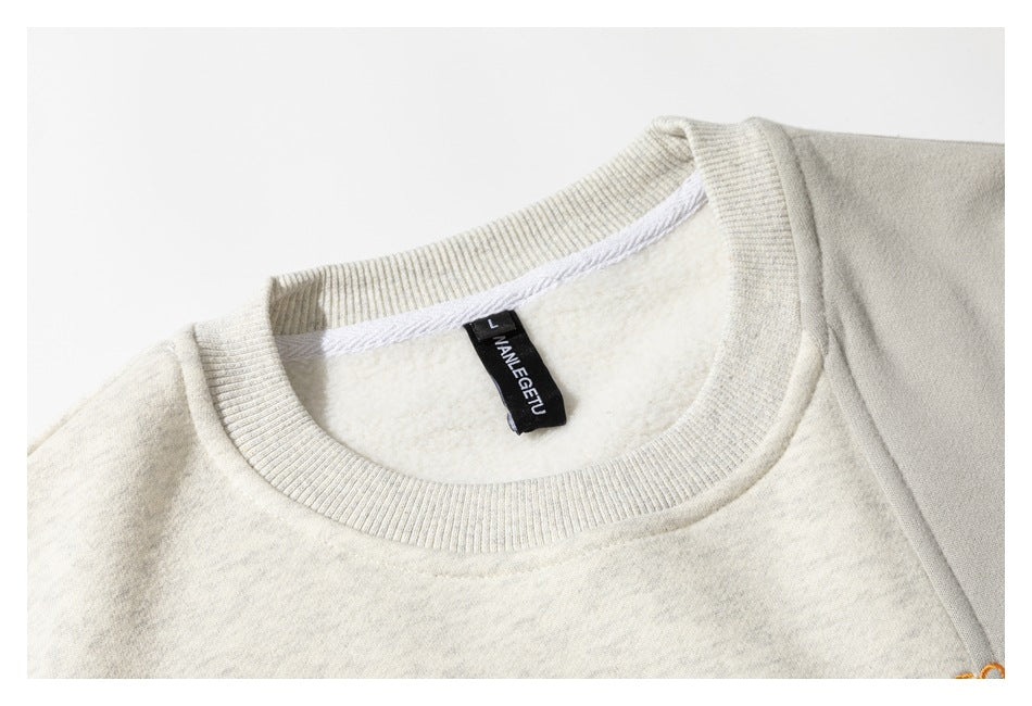 Close-up of an off-white sweatshirt showing its ribbed crew neckline, inner label, and soft-looking interior.