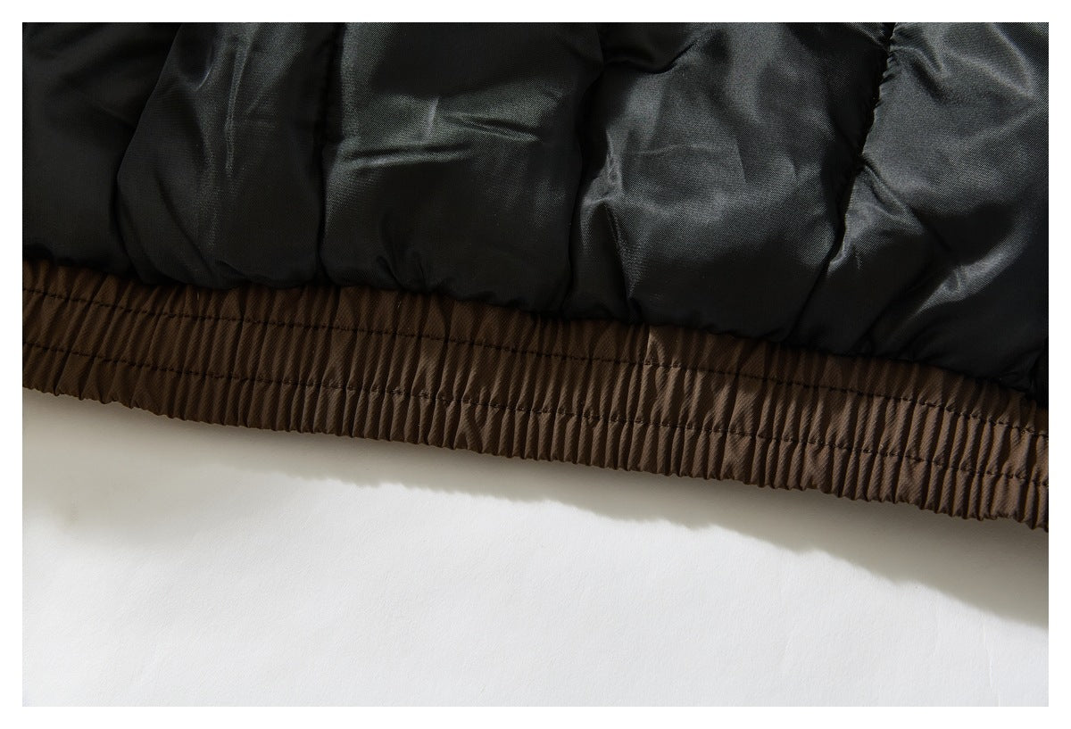 Close-up of black quilted jacket lining above a gathered brown elastic hem.