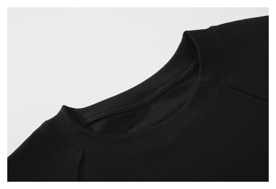 Close-up of the black shirt's ribbed crew neckline and shoulder seam.
