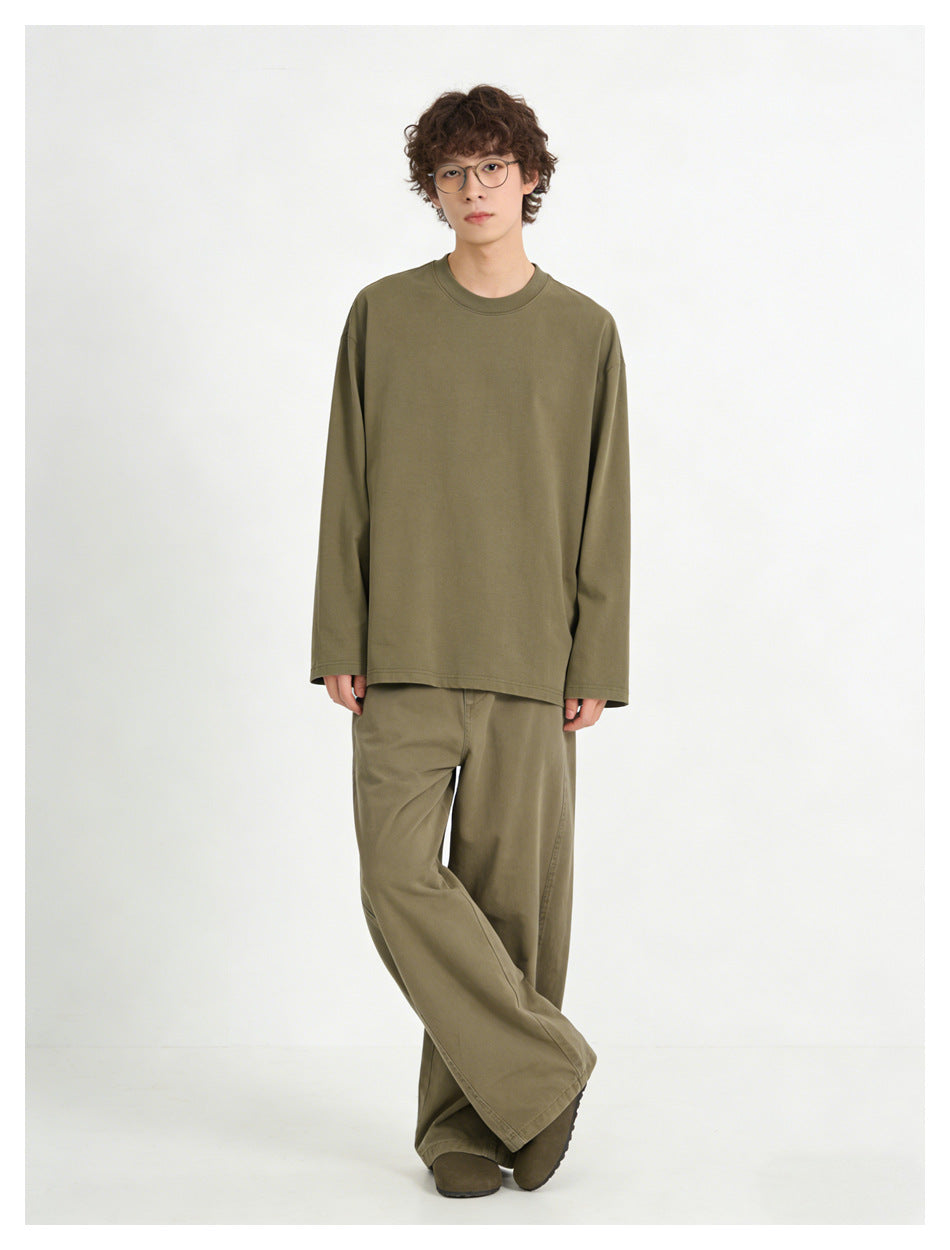 Model wearing an olive long-sleeve crewneck top with matching loose trousers, shown from the front.