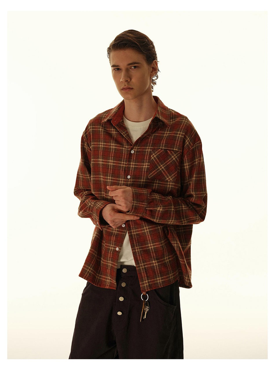 Model wearing a red-brown plaid button-up shirt over a white tee, shown from the front.