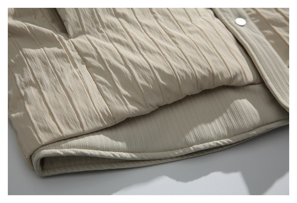 Close-up of the cream jacket’s lower crinkled panels and ribbed hem.