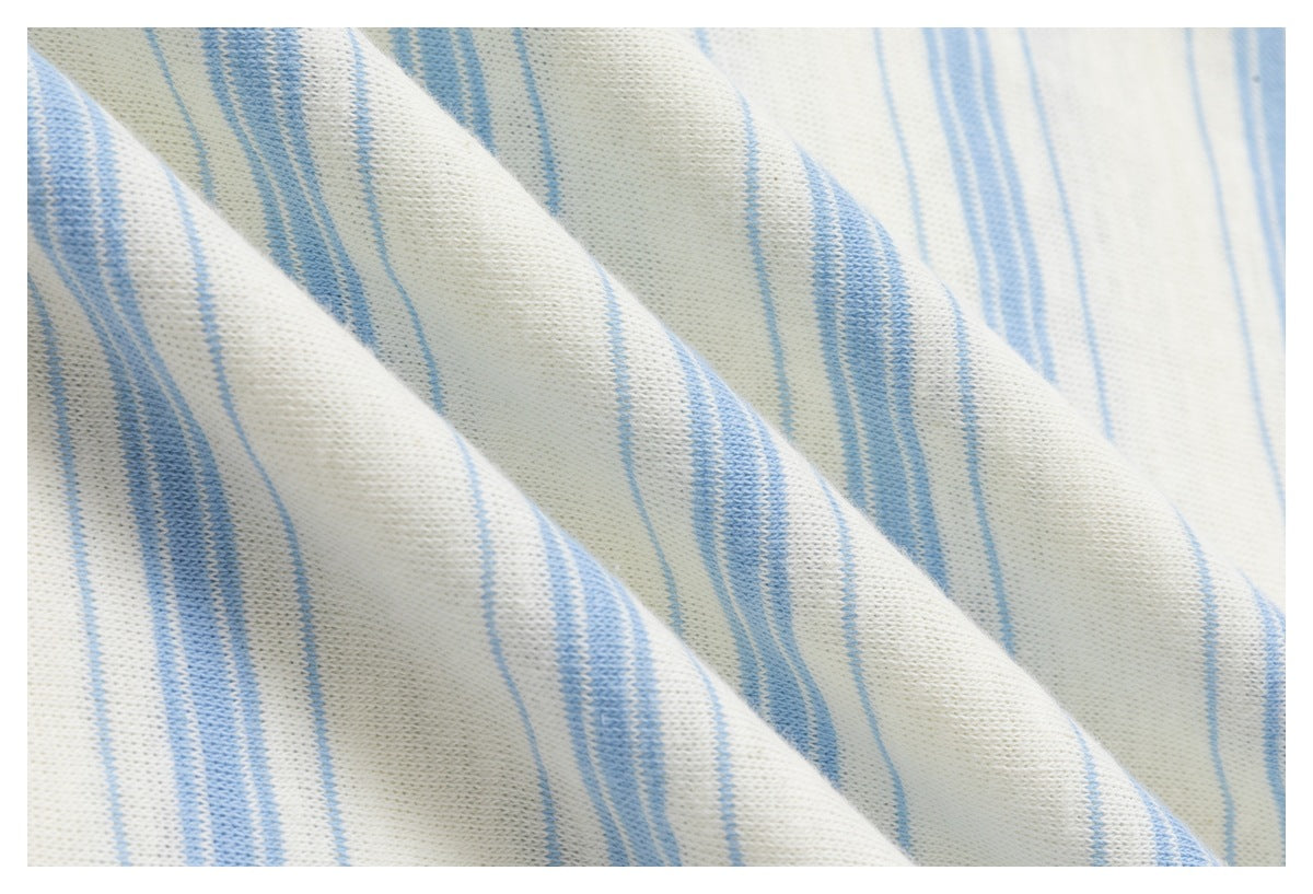 Macro view of the knit texture and pale blue stripes on off-white fabric.