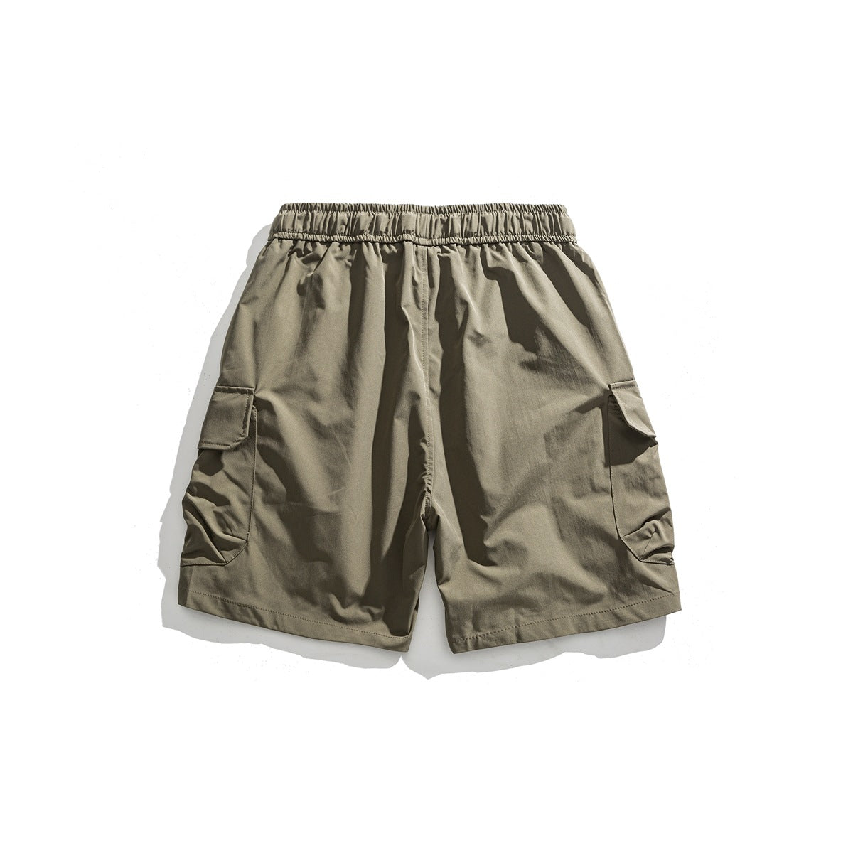 Back view of khaki cargo shorts with an elastic waistband and flap pockets at the sides.