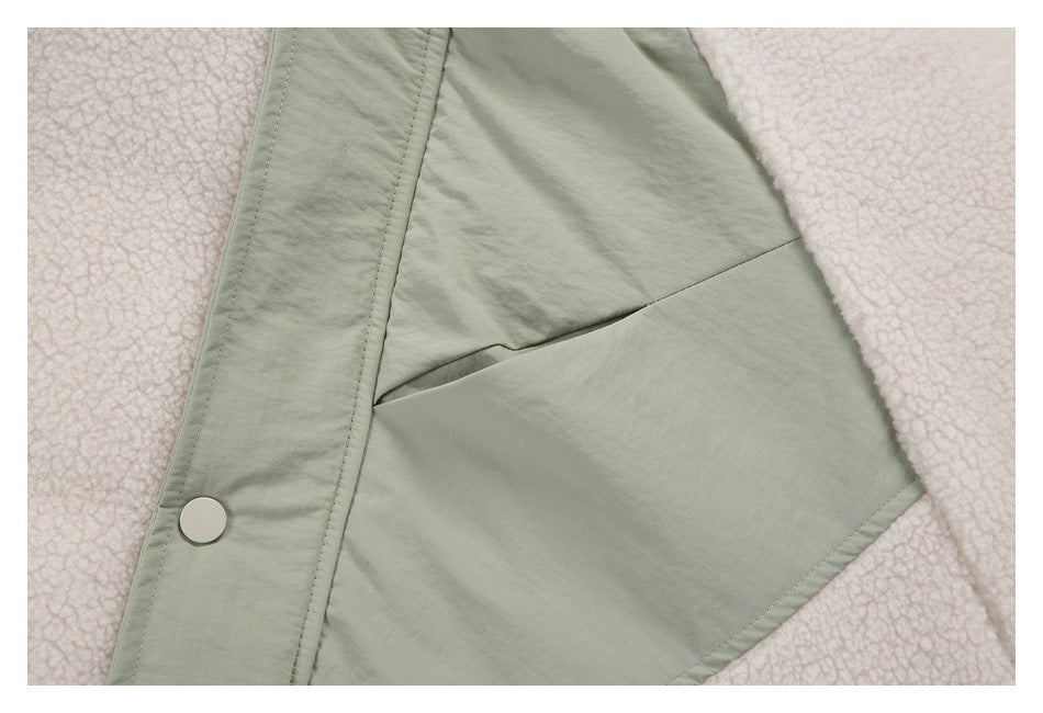 Close-up of a sage-green jacket panel, front snap, and cream fleece sections.